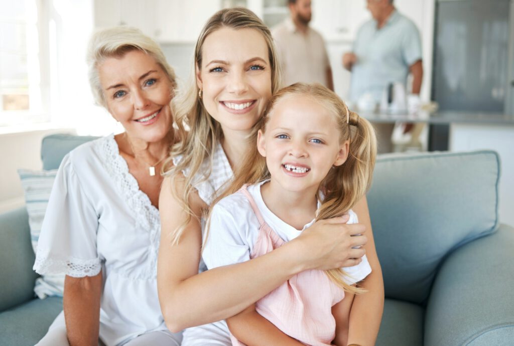 Family, love and generations with a girl, mother and grandmother sitting on a living room sofa in t